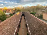 high angle view of two parallel building roofs with cobbled path between