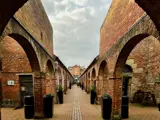 red brick arches either side of cobbled path