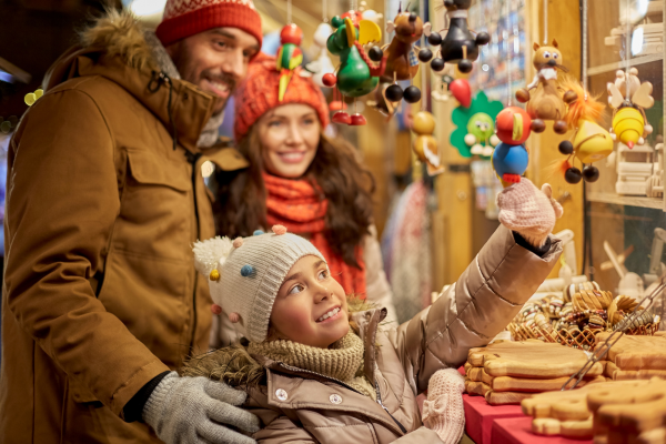 family admiring ornaments on winter market stall