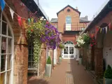 hanging baskets in brick built alley