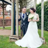 Bride and groom standing under wooden frame