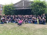 large group of people gathered together in outdoor theatre singing