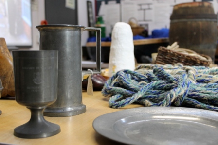 pewter cups and plates on display table